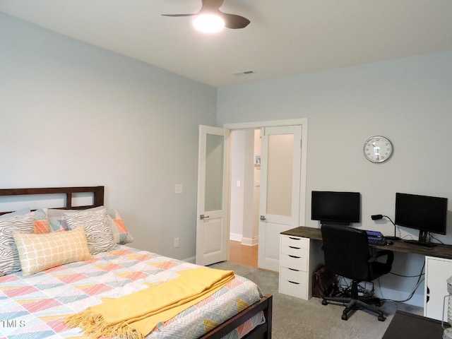 bedroom with baseboards, visible vents, a ceiling fan, and light colored carpet