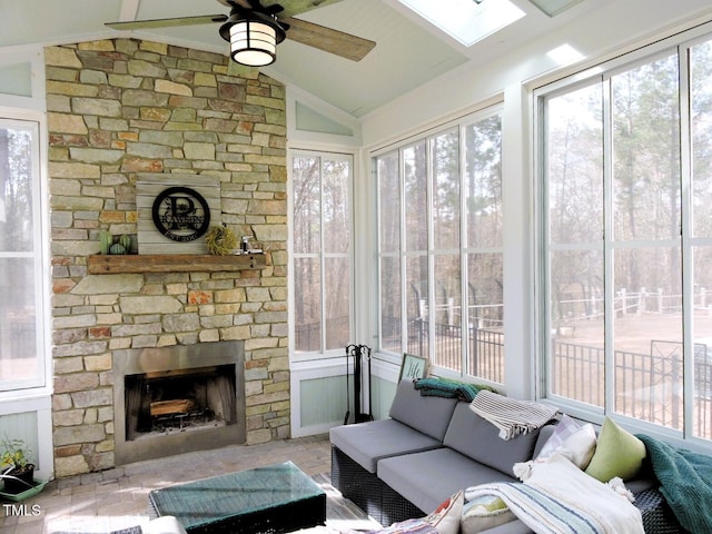 sunroom featuring lofted ceiling, a fireplace, and ceiling fan