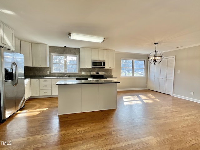 kitchen with dark countertops, backsplash, stainless steel appliances, and a sink