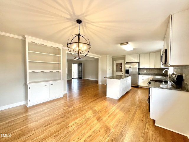 kitchen with a center island, stainless steel appliances, light wood-style flooring, ornamental molding, and open floor plan