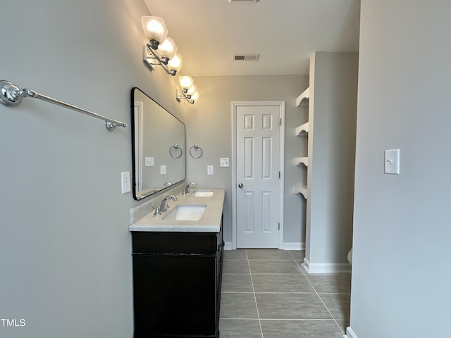 bathroom featuring double vanity, baseboards, visible vents, and a sink