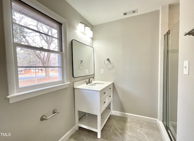 full bath with a shower with shower door, visible vents, and baseboards