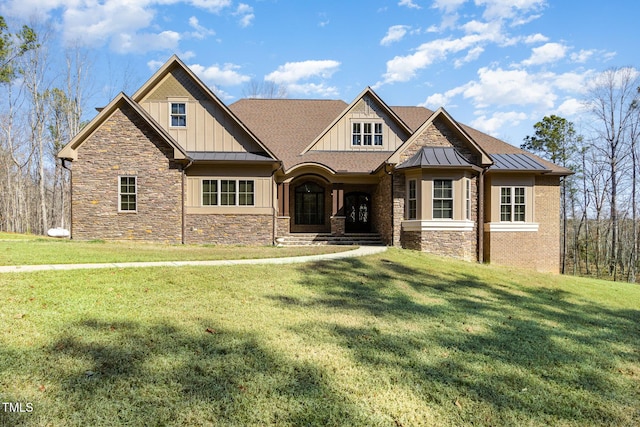 craftsman inspired home with a standing seam roof, a front yard, and board and batten siding