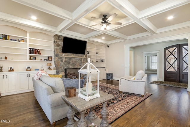 living area with a stone fireplace, dark wood-type flooring, beamed ceiling, and coffered ceiling