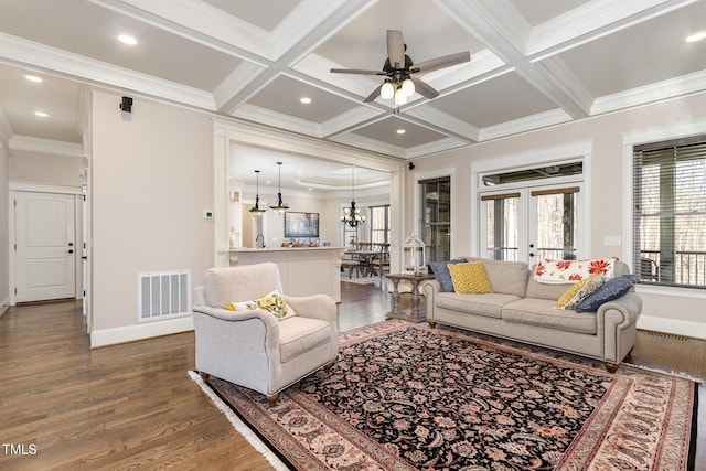 living area featuring visible vents, dark wood finished floors, ornamental molding, beam ceiling, and coffered ceiling