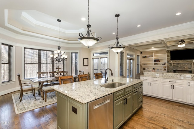 kitchen with dark wood finished floors, a sink, crown molding, and stainless steel dishwasher