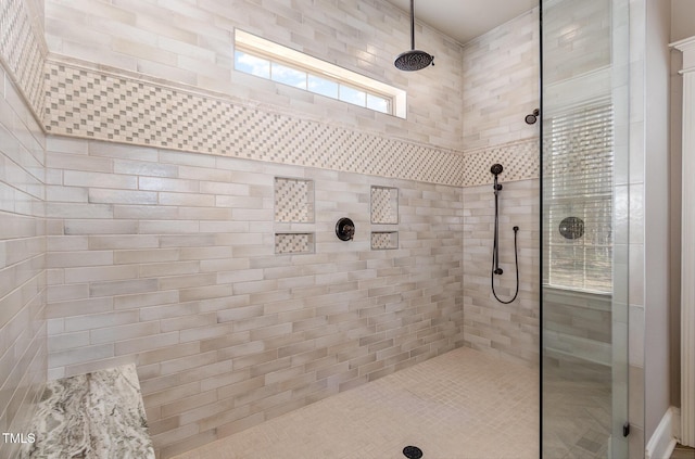 bathroom with a healthy amount of sunlight and tiled shower