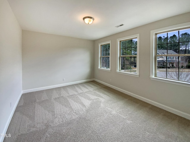 carpeted empty room with visible vents and baseboards