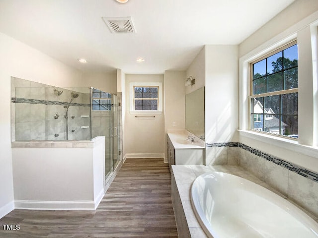 bathroom with a stall shower, visible vents, a garden tub, and wood finished floors