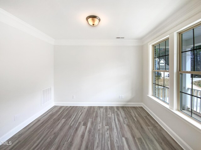 unfurnished room with baseboards, visible vents, and crown molding