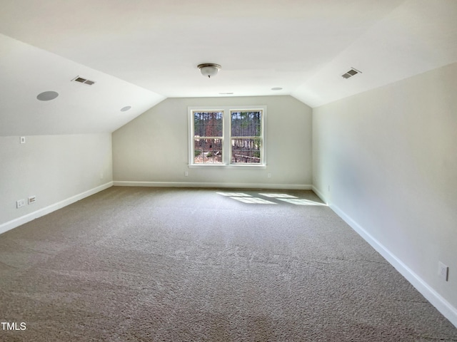 bonus room with baseboards, visible vents, vaulted ceiling, and carpet flooring