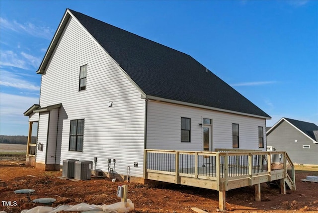 back of property featuring roof with shingles, a deck, and central AC unit