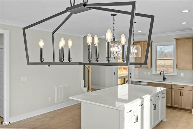 kitchen with visible vents, ornamental molding, a sink, light wood-style floors, and backsplash