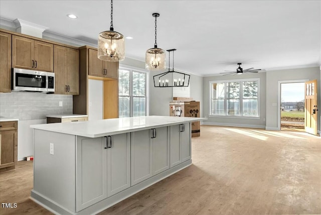 kitchen with stainless steel microwave, backsplash, and ornamental molding