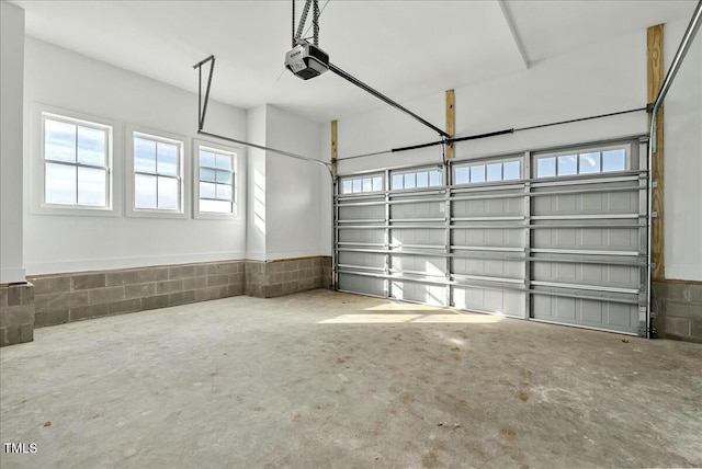 garage featuring a garage door opener and concrete block wall