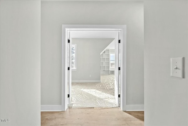 corridor with wood finished floors and baseboards