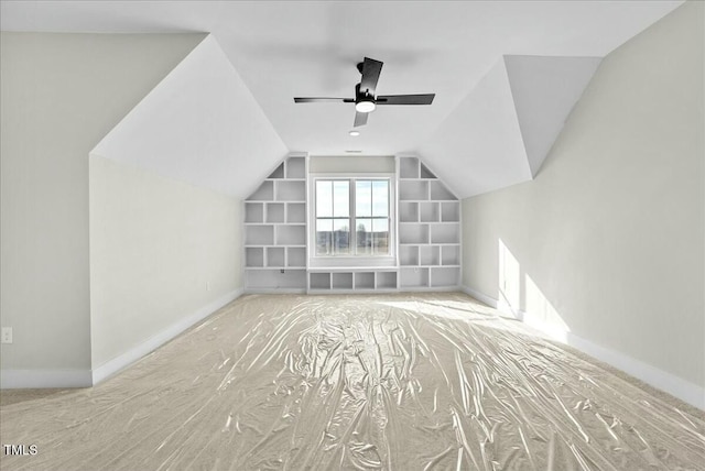 bonus room featuring built in features, vaulted ceiling, baseboards, and a ceiling fan