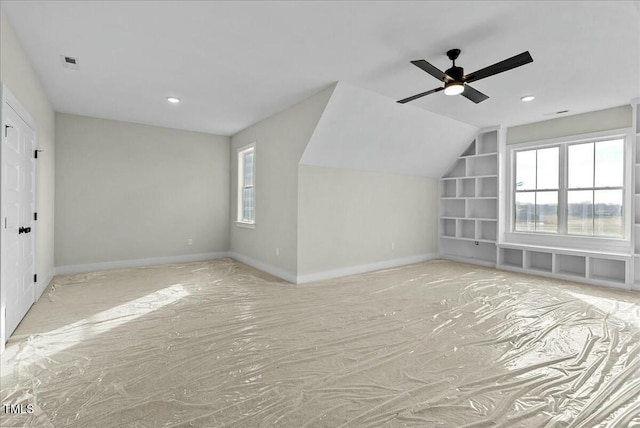 bonus room with lofted ceiling, built in shelves, a ceiling fan, visible vents, and baseboards