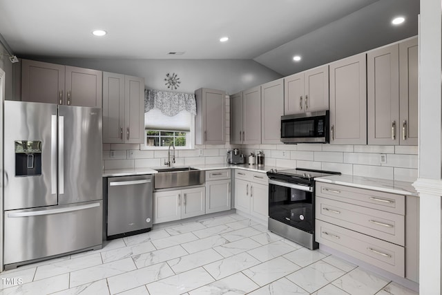 kitchen featuring marble finish floor, stainless steel appliances, a sink, and light countertops