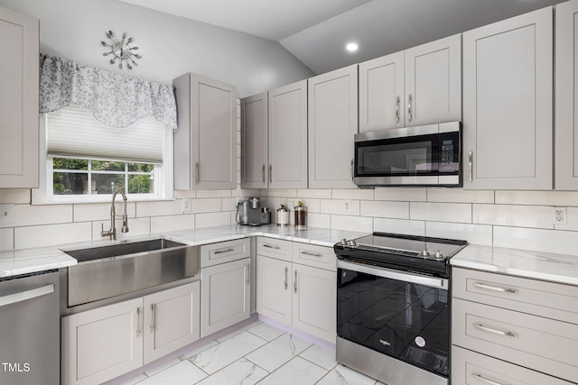 kitchen with marble finish floor, appliances with stainless steel finishes, a sink, and decorative backsplash