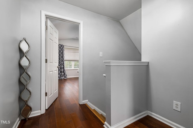 corridor with dark wood-style flooring, baseboards, and an upstairs landing