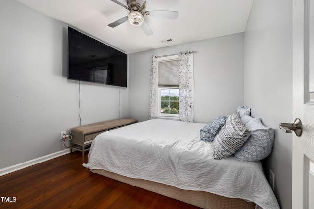 bedroom with ceiling fan, wood finished floors, visible vents, and baseboards