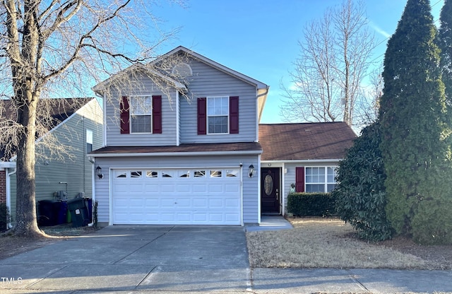 traditional home featuring concrete driveway and an attached garage