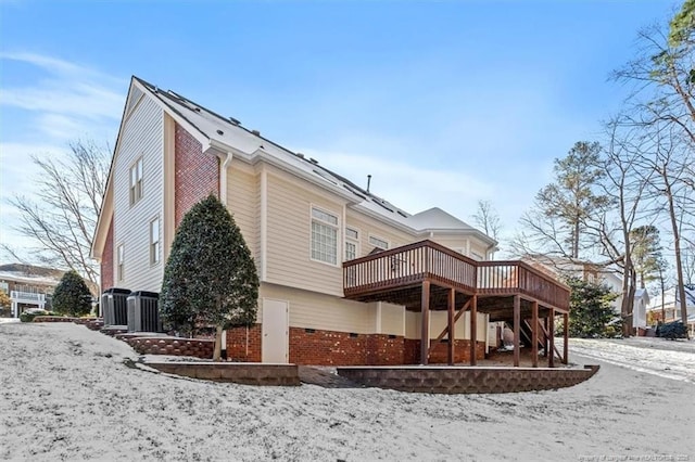 snow covered house featuring crawl space and a deck