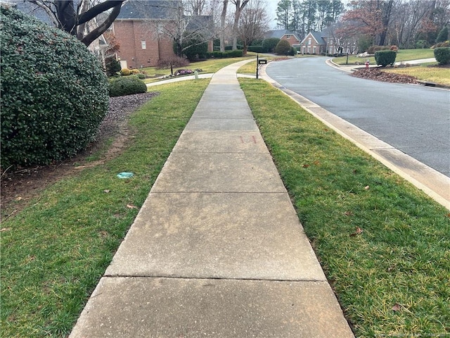 view of street featuring curbs, sidewalks, and a residential view