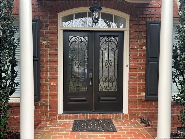 doorway to property with brick siding