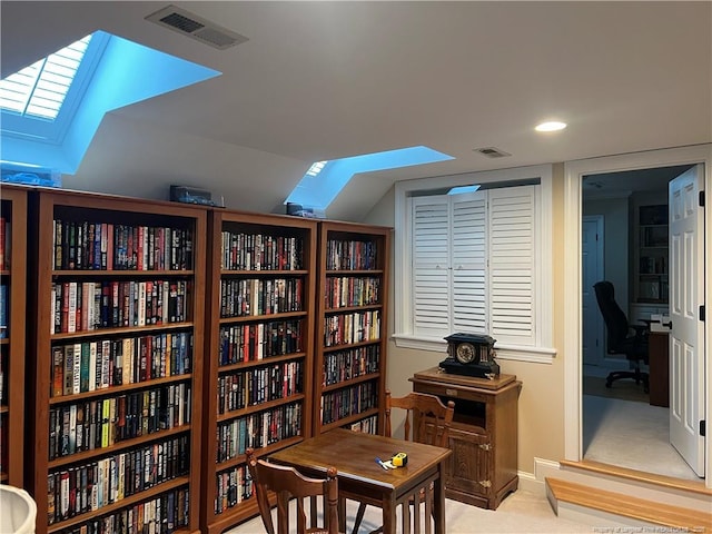 sitting room featuring carpet floors, lofted ceiling with skylight, visible vents, and baseboards