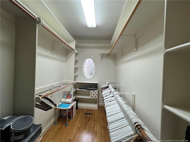 spacious closet with wood finished floors and attic access