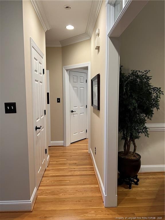 corridor featuring ornamental molding, light wood-type flooring, recessed lighting, and baseboards