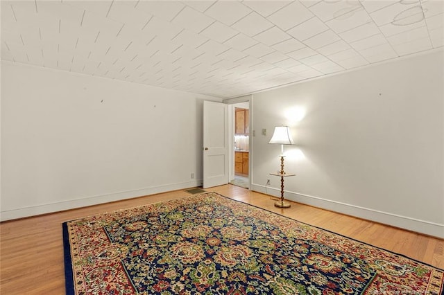 spare room featuring light wood finished floors and baseboards