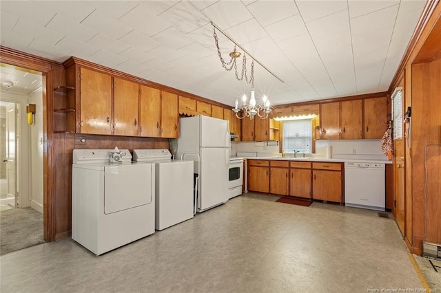 laundry room featuring a notable chandelier, laundry area, independent washer and dryer, light floors, and crown molding