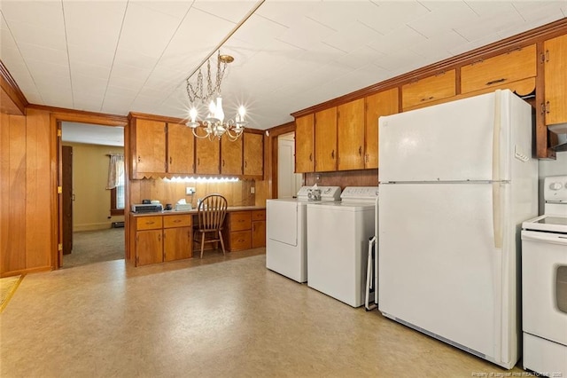 kitchen featuring brown cabinets, a notable chandelier, wooden walls, white appliances, and independent washer and dryer