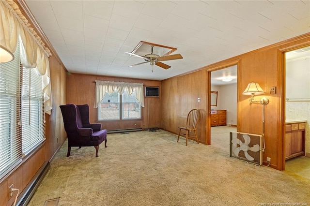 sitting room with light colored carpet, baseboard heating, a wall mounted AC, a ceiling fan, and wood walls