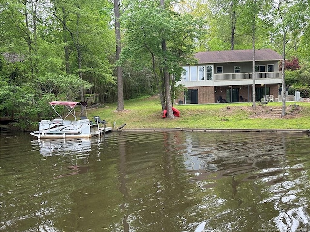 view of dock featuring a lawn and a water view