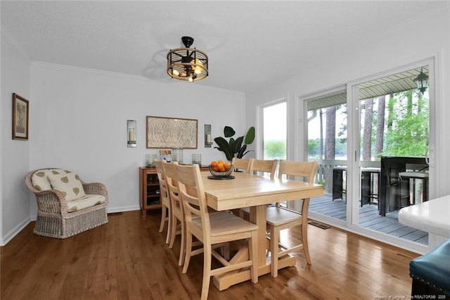 dining area featuring ornamental molding, baseboards, and wood finished floors