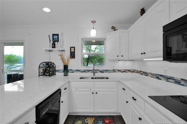 kitchen featuring a sink, white cabinetry, decorative backsplash, black appliances, and crown molding