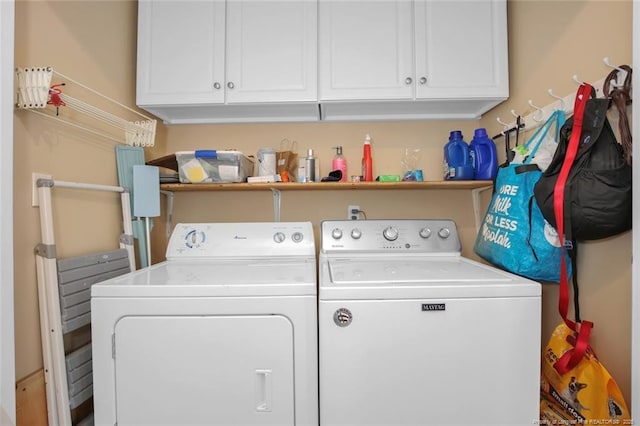 washroom featuring washing machine and dryer and cabinet space