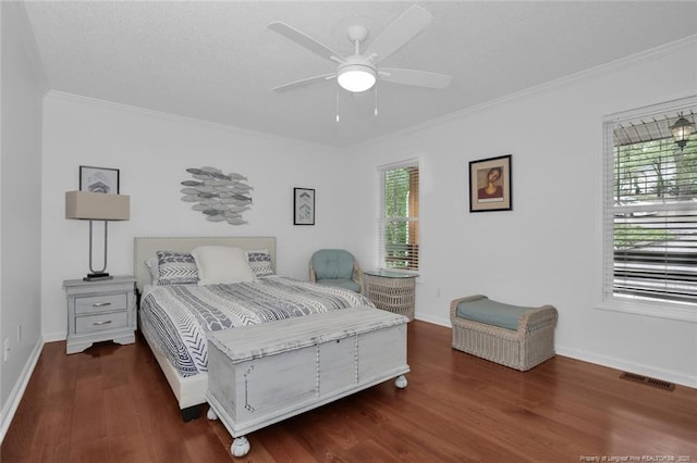 bedroom with wood finished floors, visible vents, and crown molding