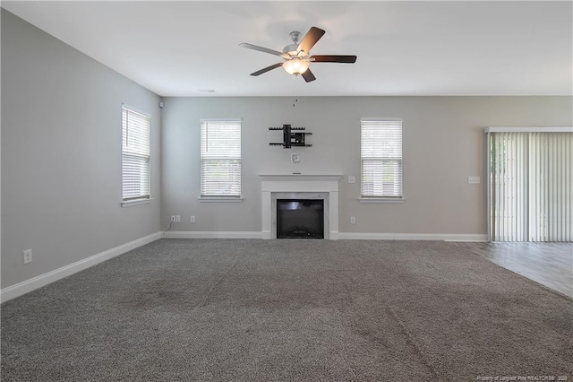 387 Springhaven Dr, Raeford, NC 28376 - unfurnished living room with a ceiling fan, baseboards, a glass covered fireplace, and carpet floors