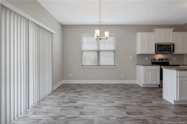 387 Springhaven Dr, Raeford, NC 28376 - kitchen with stainless steel appliances, white cabinetry, light wood-type flooring, and decorative backsplash
