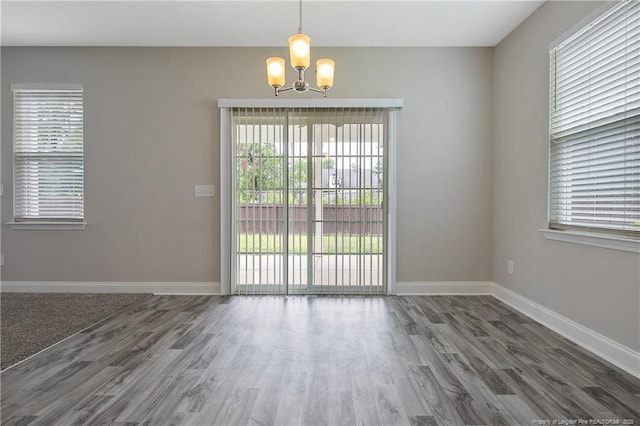 387 Springhaven Dr, Raeford, NC 28376 - unfurnished dining area with a chandelier, wood finished floors, and plenty of natural light