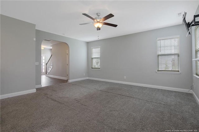 387 Springhaven Dr, Raeford, NC 28376 - empty room with arched walkways, a ceiling fan, dark carpet, and plenty of natural light