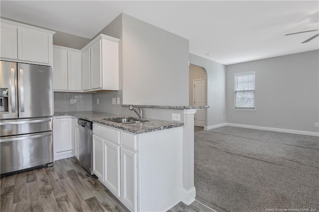 387 Springhaven Dr, Raeford, NC 28376 - kitchen with appliances with stainless steel finishes, a sink, light stone counters, white cabinetry, and backsplash