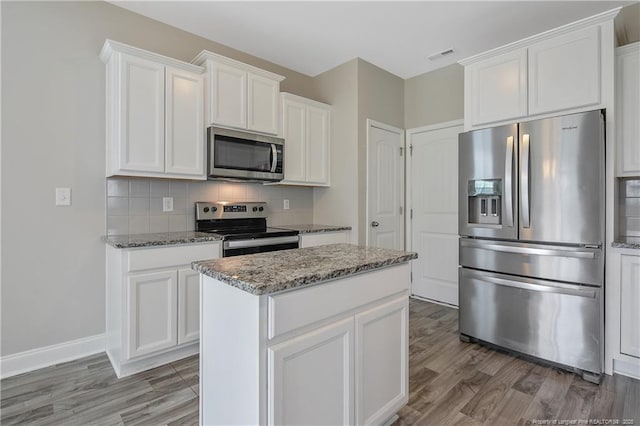 387 Springhaven Dr, Raeford, NC 28376 - kitchen featuring stainless steel appliances, backsplash, light stone countertops, and white cabinetry