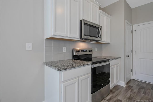 387 Springhaven Dr, Raeford, NC 28376 - kitchen featuring appliances with stainless steel finishes, tasteful backsplash, white cabinets, wood finished floors, and light stone countertops