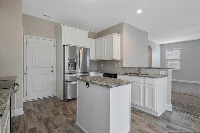 387 Springhaven Dr, Raeford, NC 28376 - kitchen featuring stainless steel appliances, a sink, a peninsula, light stone countertops, and recessed lighting